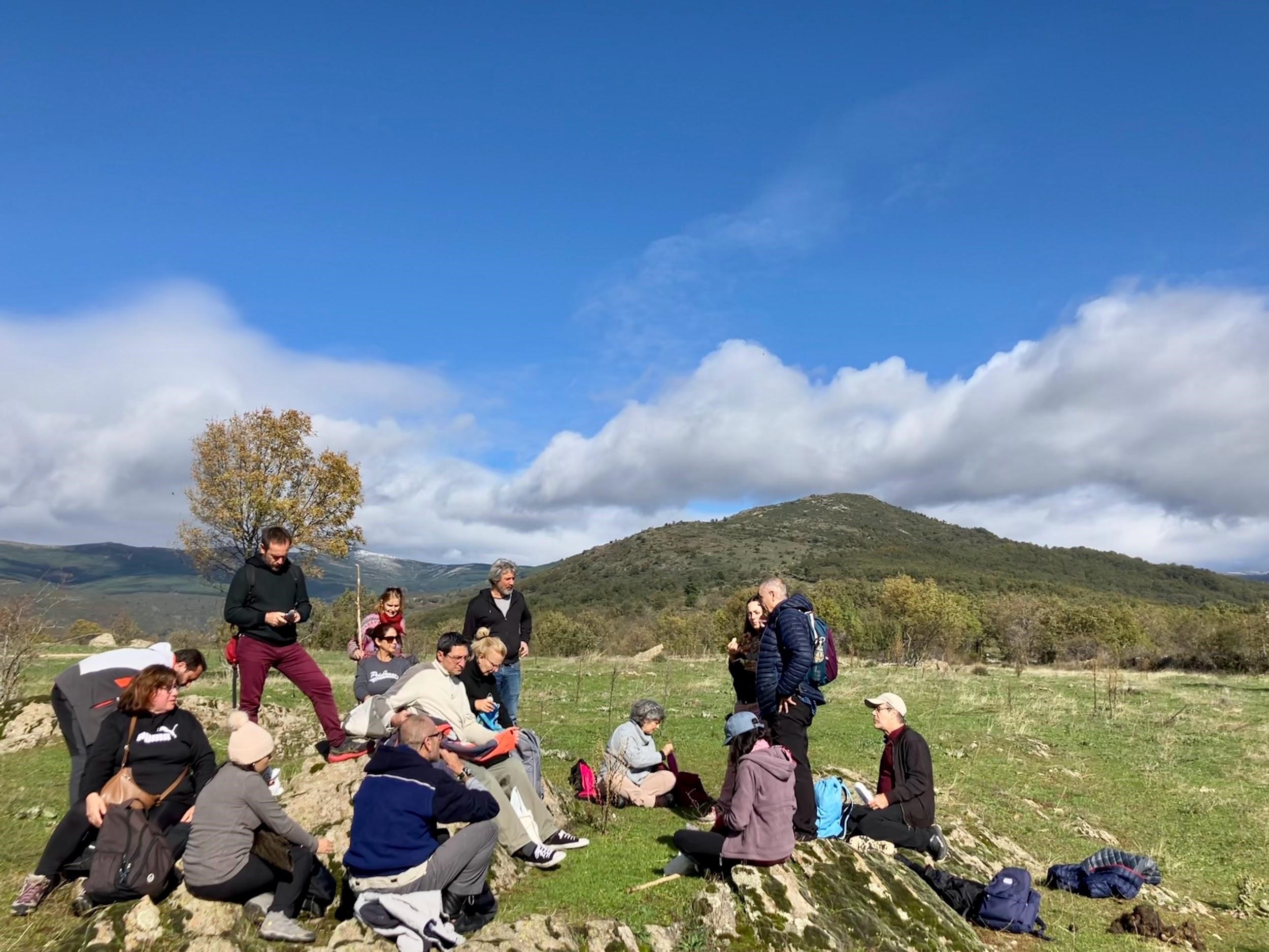 Los participantes en la jornada hacen un alto en el camino mientras escuchan a los investigadores del CCHS-CSIC explicar la historia de la sierra madrileña y su gente. / Jon Gurutz Arranz Izquierdo